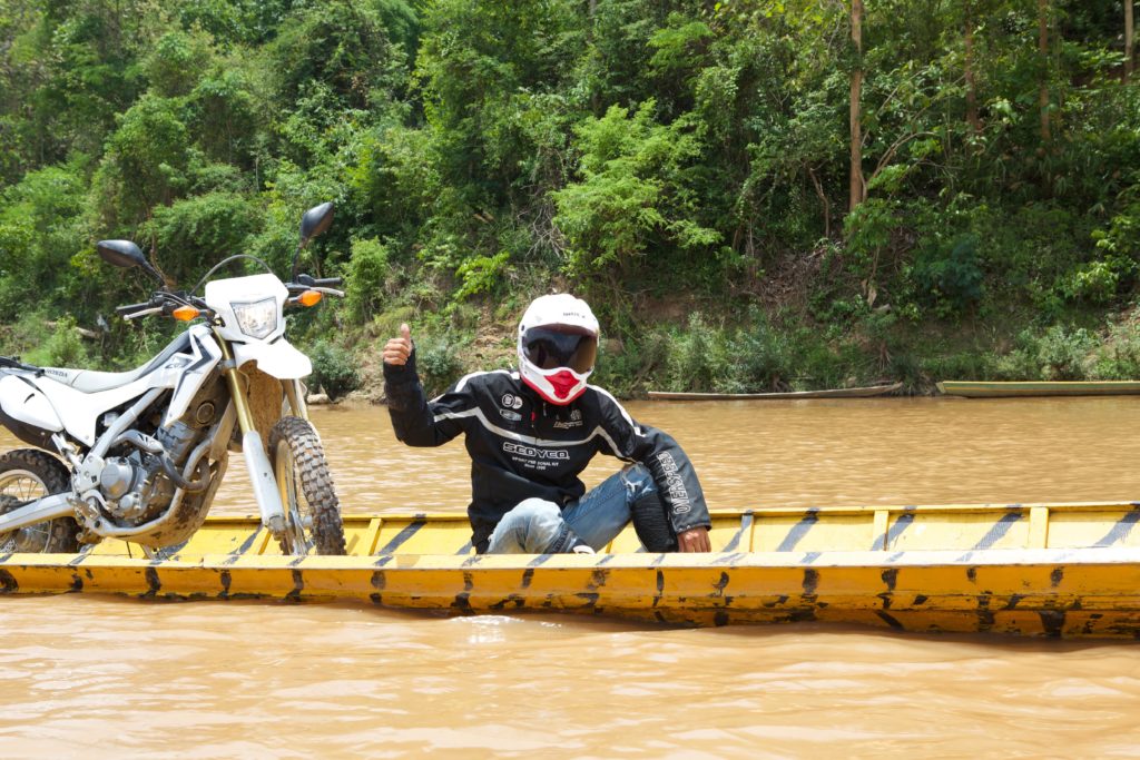 The Best Time to Take an Off-road Motorcycle Tour in Northern Laos Copy of laos khmou village homestay motorbike rider in boat tiger trail photo by cyril eberle CEB 9994 1024x683 - The Best Time to Take an Off-road Motorcycle Tour in Northern Laos